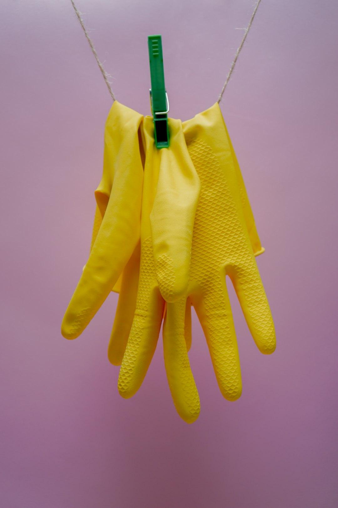 Paire de gants de ménage réutilisables posée sur le rebord d'un évier