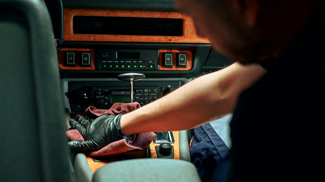 Un professionnel nettoie les sièges intérieurs d'une voiture.