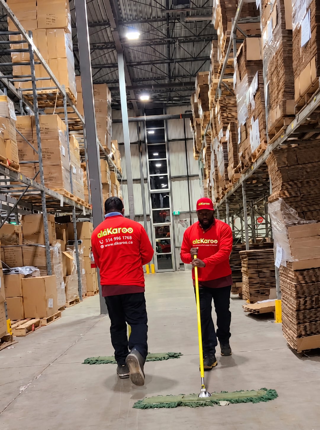 Une préposée de DIKAROO souriante, en uniforme, dans un hall de bureaux au petit matin